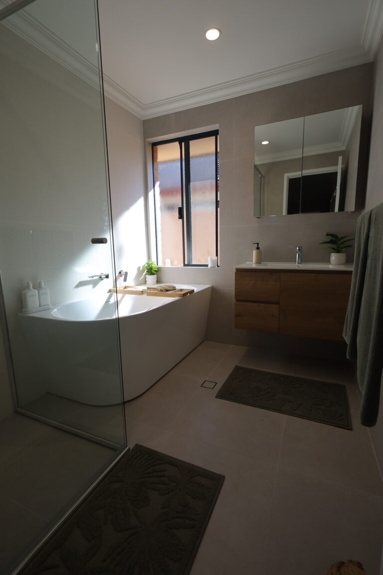 Freestanding bath with a glass screen and wall-hung vanity in an Atwell bathroom renovation, Perth